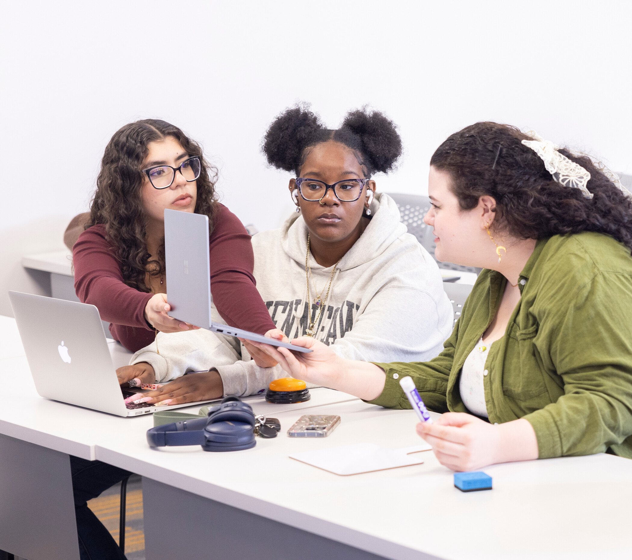 A learning assistant works with a group of students in a classroom