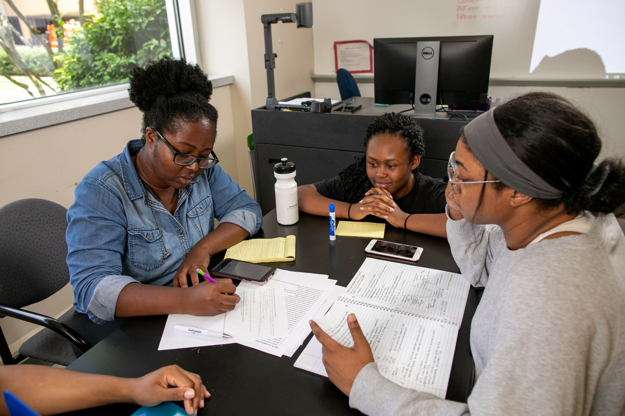 An SI leader leads a group of students in a study session