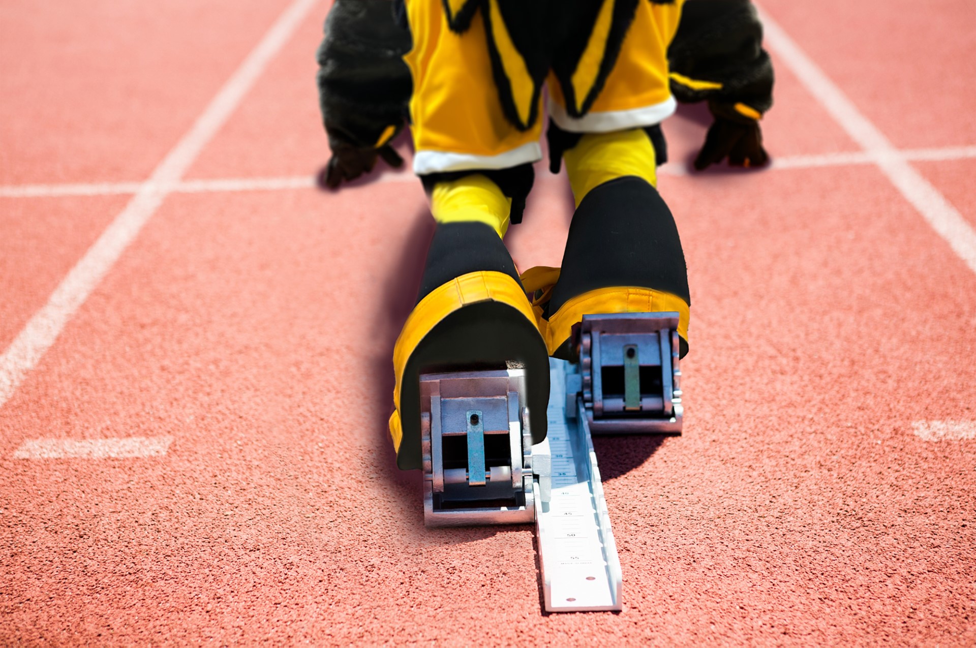 Scrappy using starting blocks on a track at the start of a race