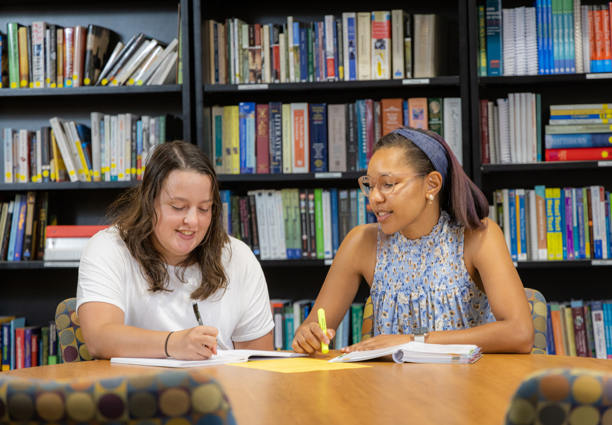 A tutor and a student are sitting down together reviewing a paper