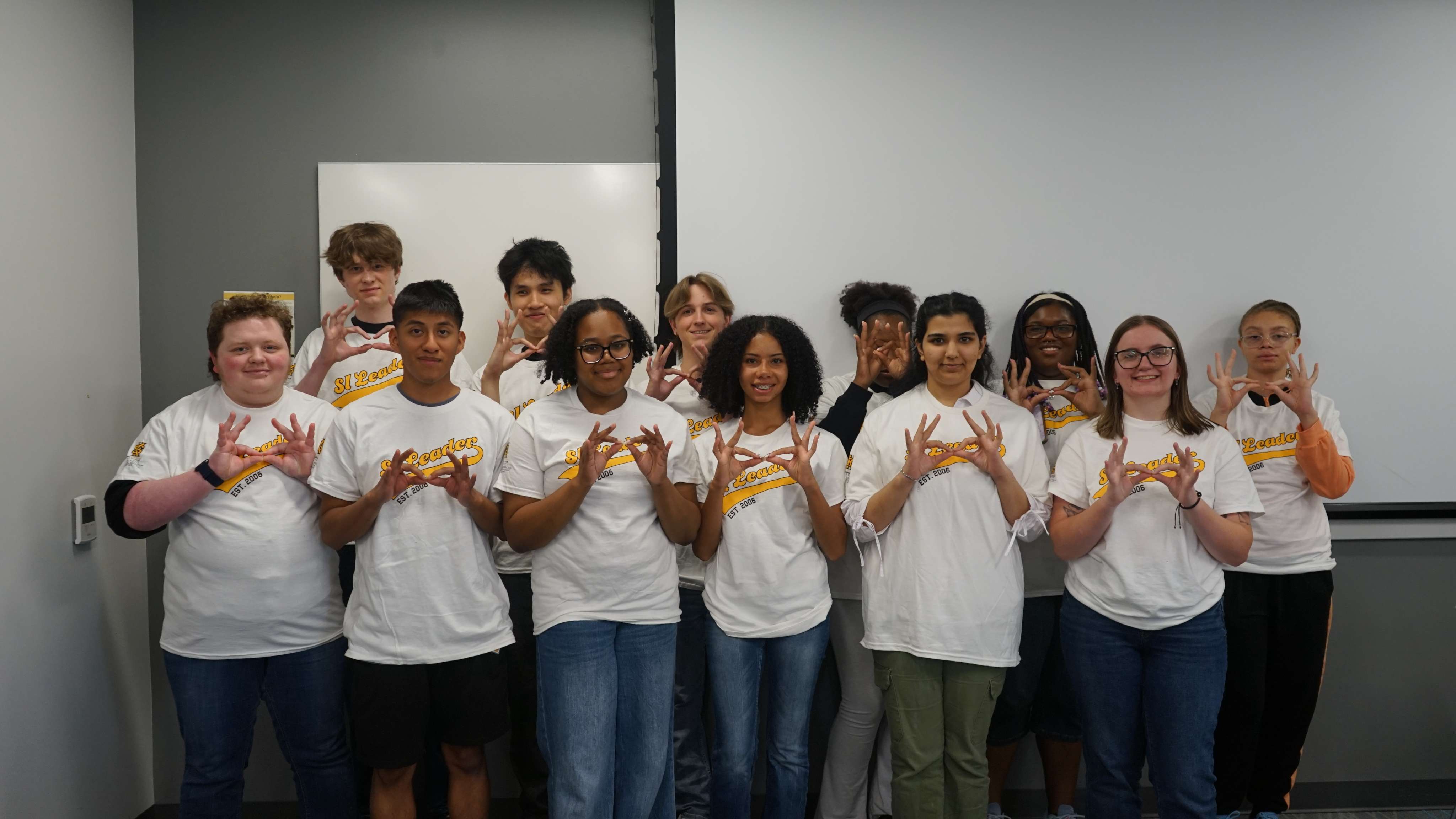 SI Leaders holding up owl eyes hand sign.