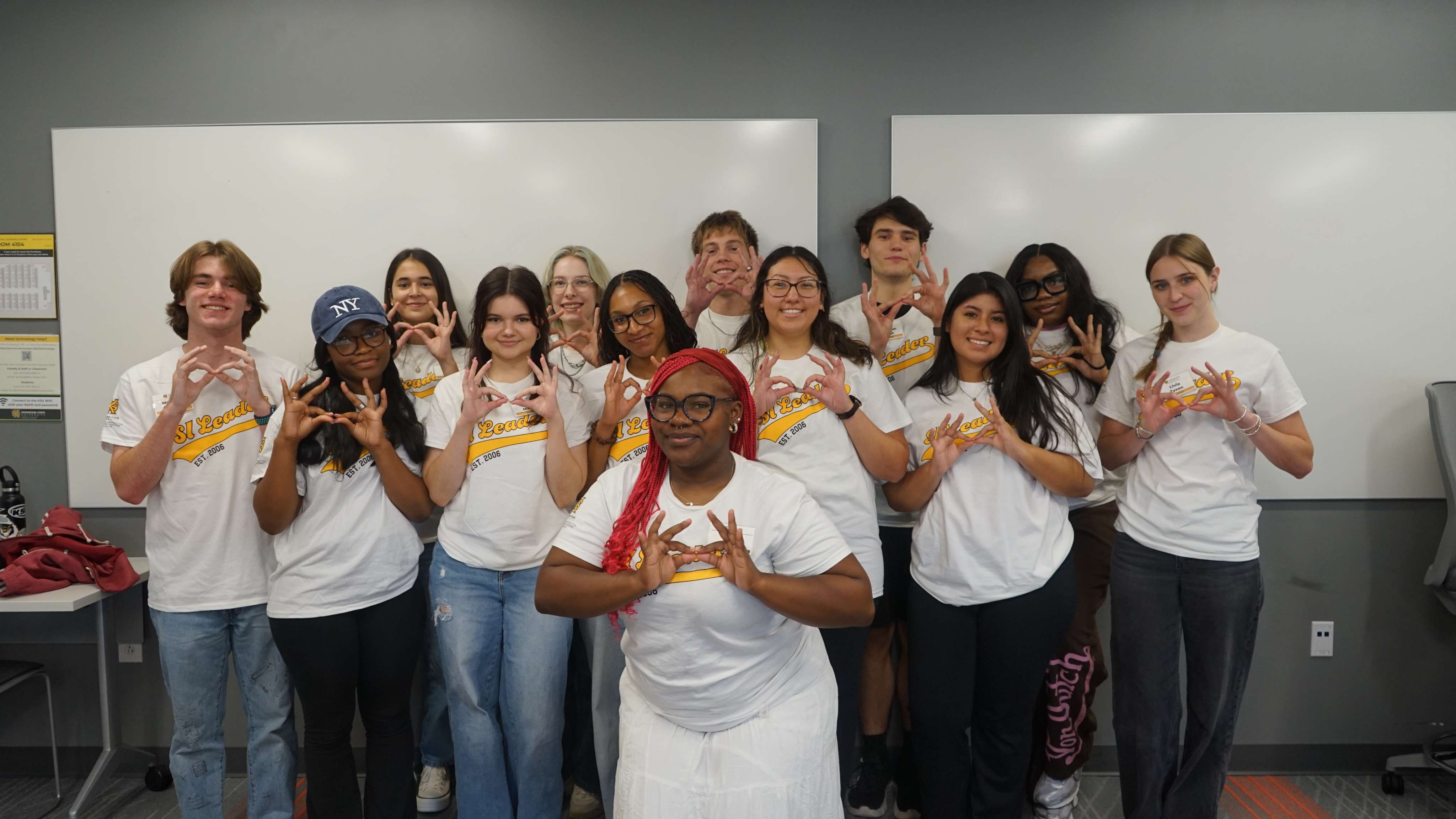 SI Leaders holding up the owl eyes hand sign.