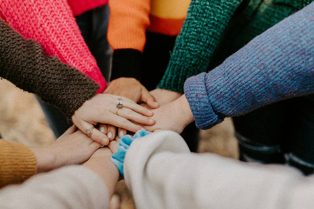 group of hands all coming together in a circle