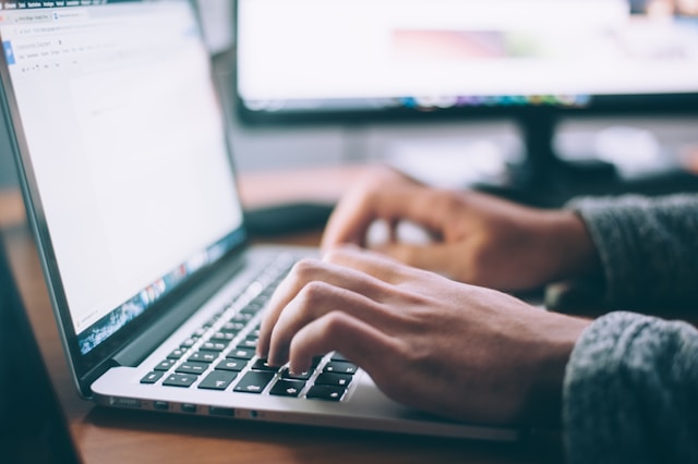 person typing on a laptop keyboard