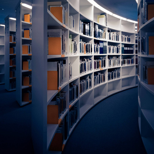 A library featuring books on shelves and a circular wall, emphasizing a space for self-directed learning.