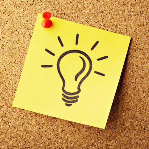 Yellow sticky note on cork board featuring a light bulb icon, symbolizing self-directed learning concepts.