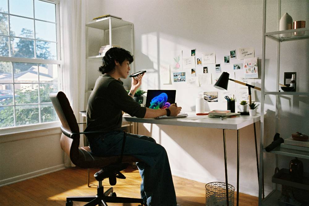 person working at a desk with copilot open on their laptop