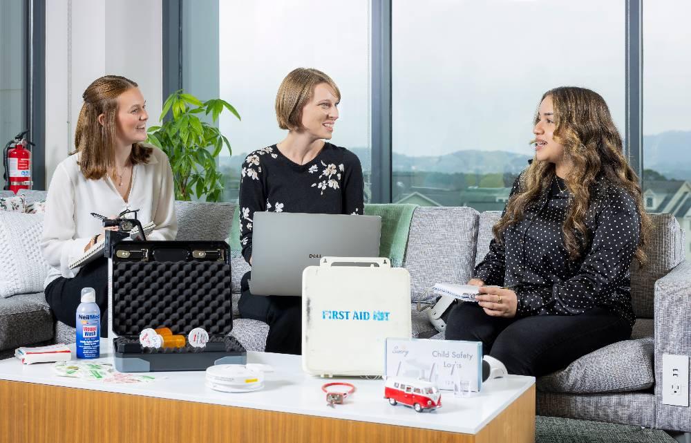 three people sitting on a couch and collaborating on a project