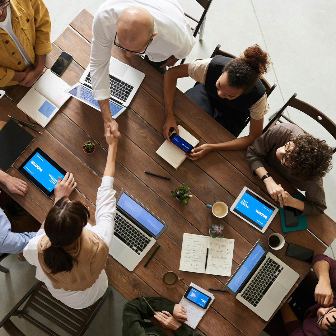 group of team working in office at large table with computers out