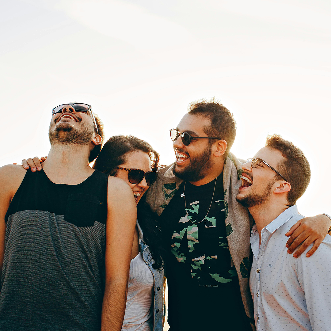 group of friends outside smiling and holding eachother