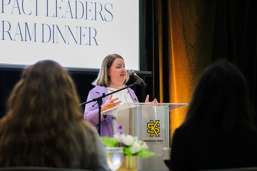 HILP Dinner 2025-2026 / A woman in a purple blazer speaks at a podium with a microphone, during the Impact Leaders Program Dinner at Kennesaw State University.