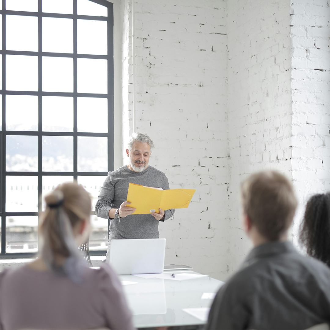man infront of audience speaking at podium