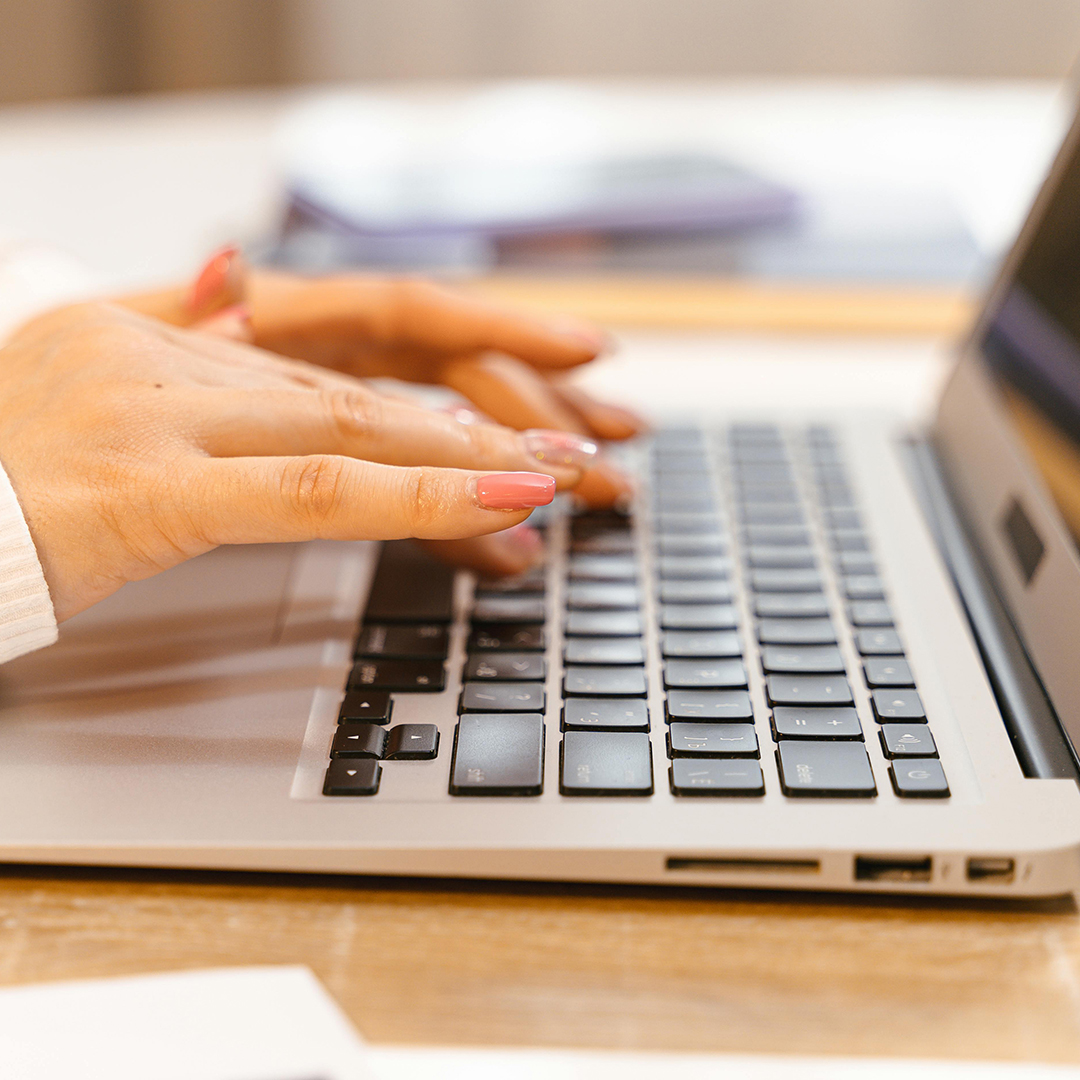 close up on females hands as she types on computer