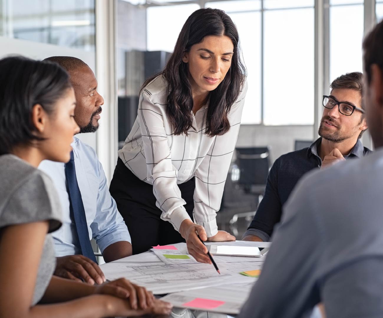 female leader leading a group discussion and writing on a paper