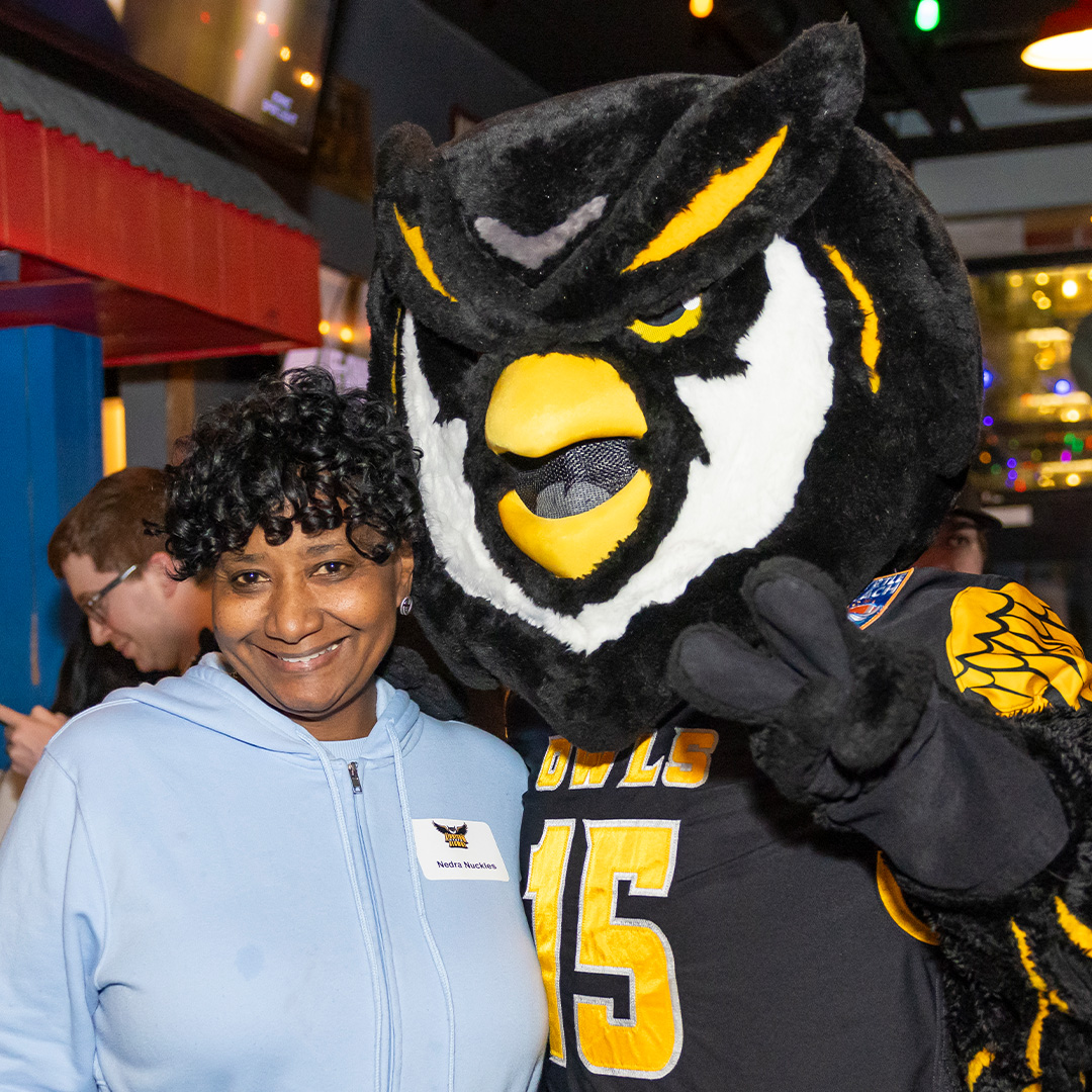 faculty member taking a picture with scrappy mascot
