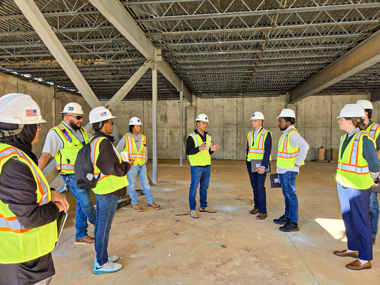 students at a job site in hardhats and reflector vests