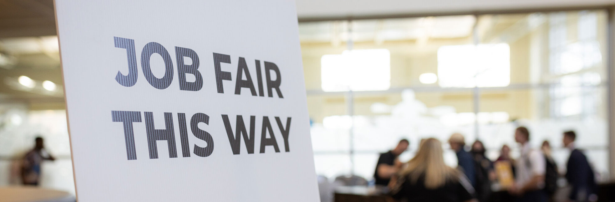 job fair this way sign with crowd in background