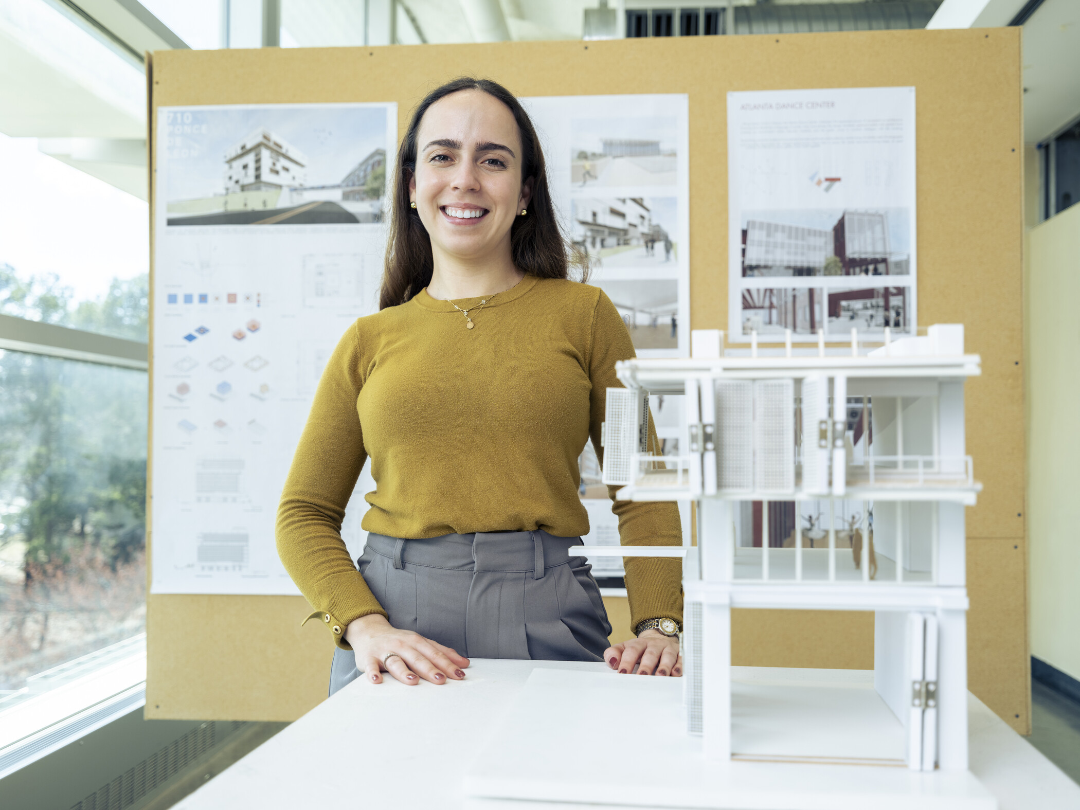 architecture student poses with a model