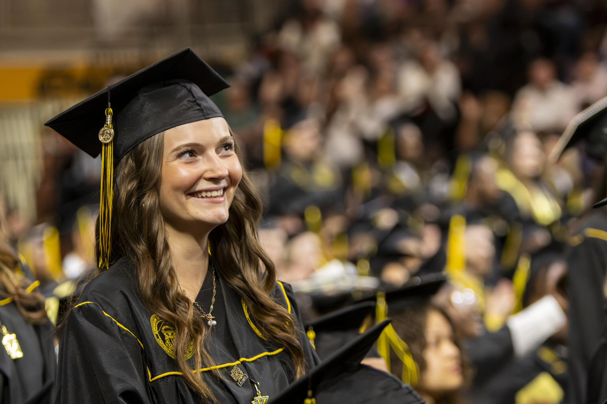 A graduate smiles proudly at commencement