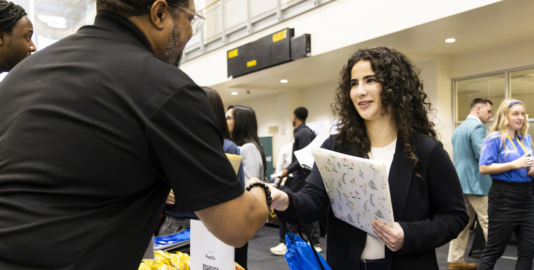 student and employer shake hands at a job fair