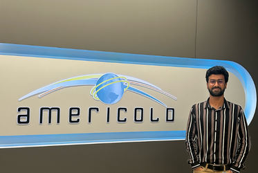 Rohan Bhuin stands in front of the Americold sign.