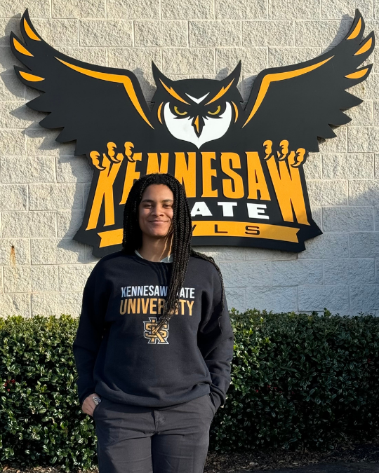 Maya Phillips standing in front of KSU sign.