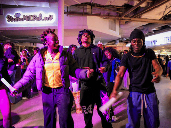 students dancing in a purple light