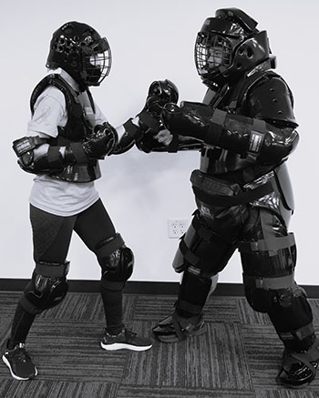 Two people in gear facing off