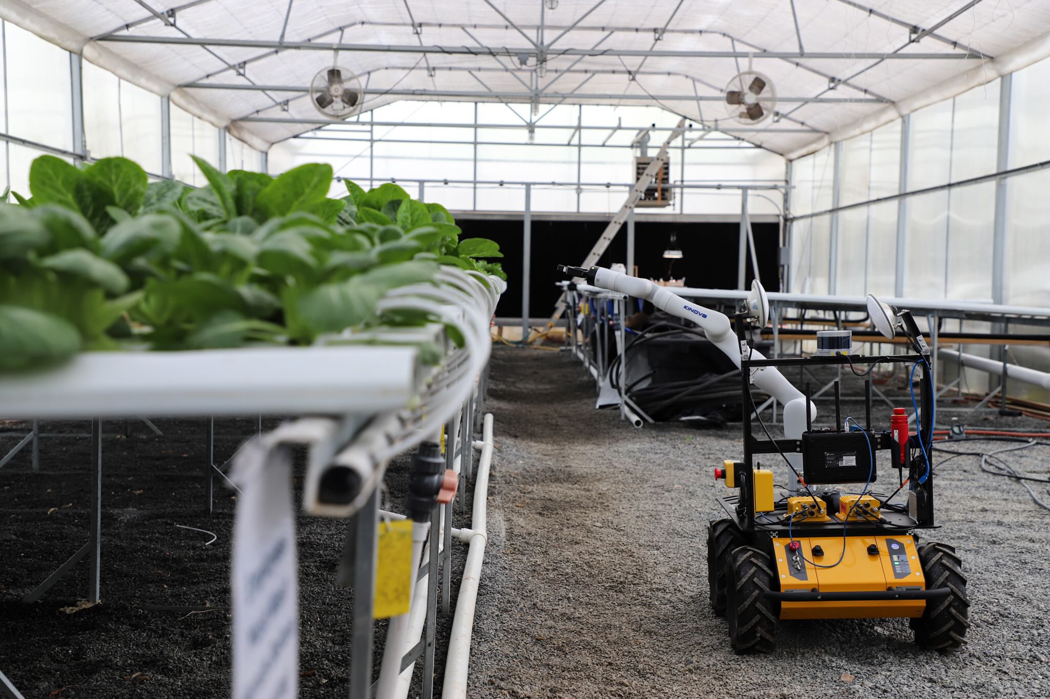 vehicle with robotic arm inside a greenhouse
