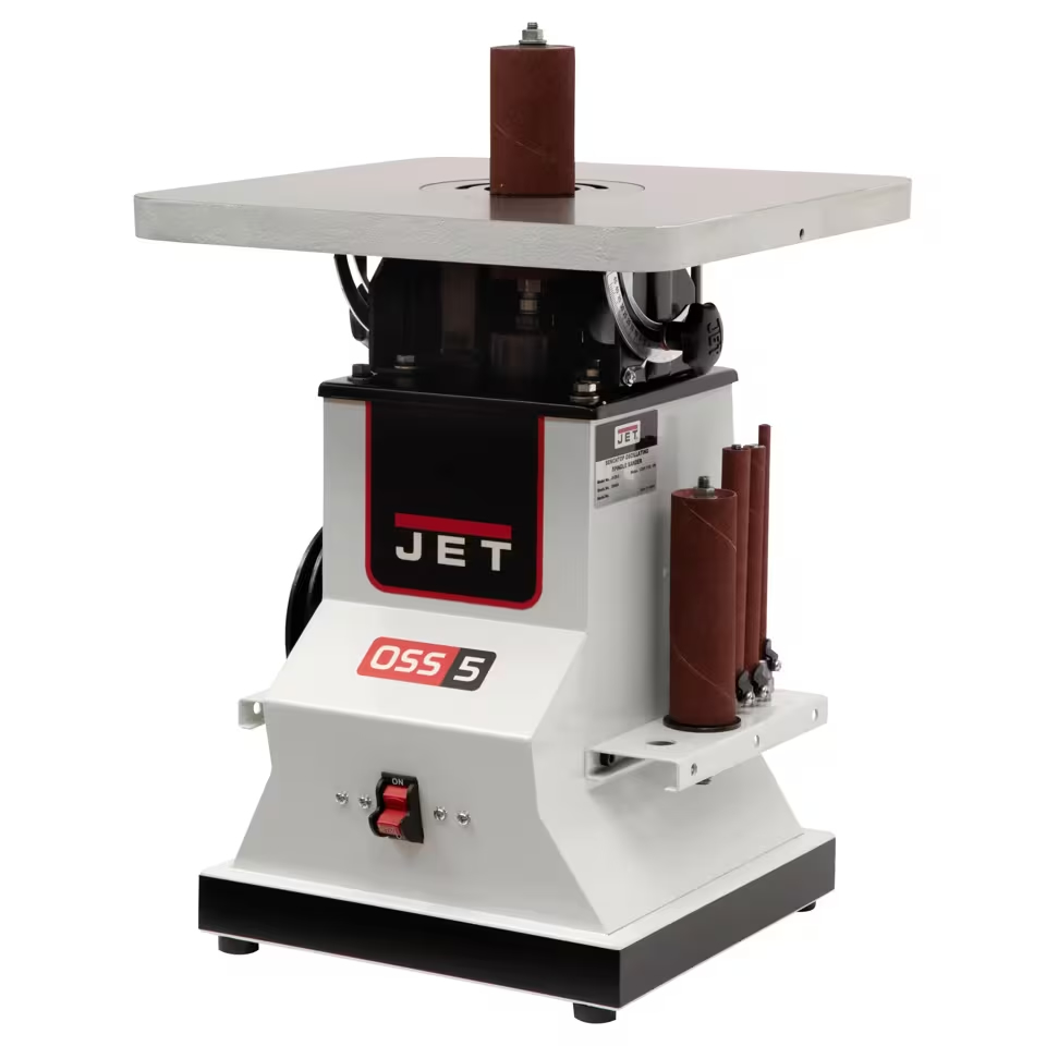 JET OSS 5 oscillating spindle sander with a gray worktable, vertical sanding spindle, and spare sanding sleeves on the side.