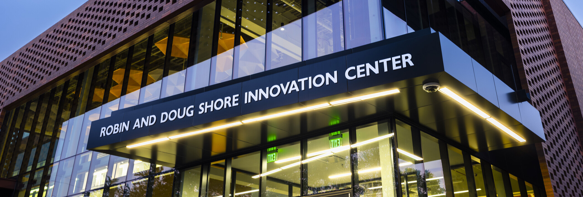 Entrance of the Robin and Doug Shore Innovation Center beneath a dark illuminated canopy.