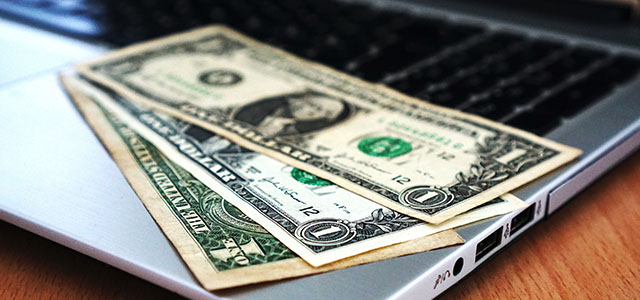us dollar bills on a laptop