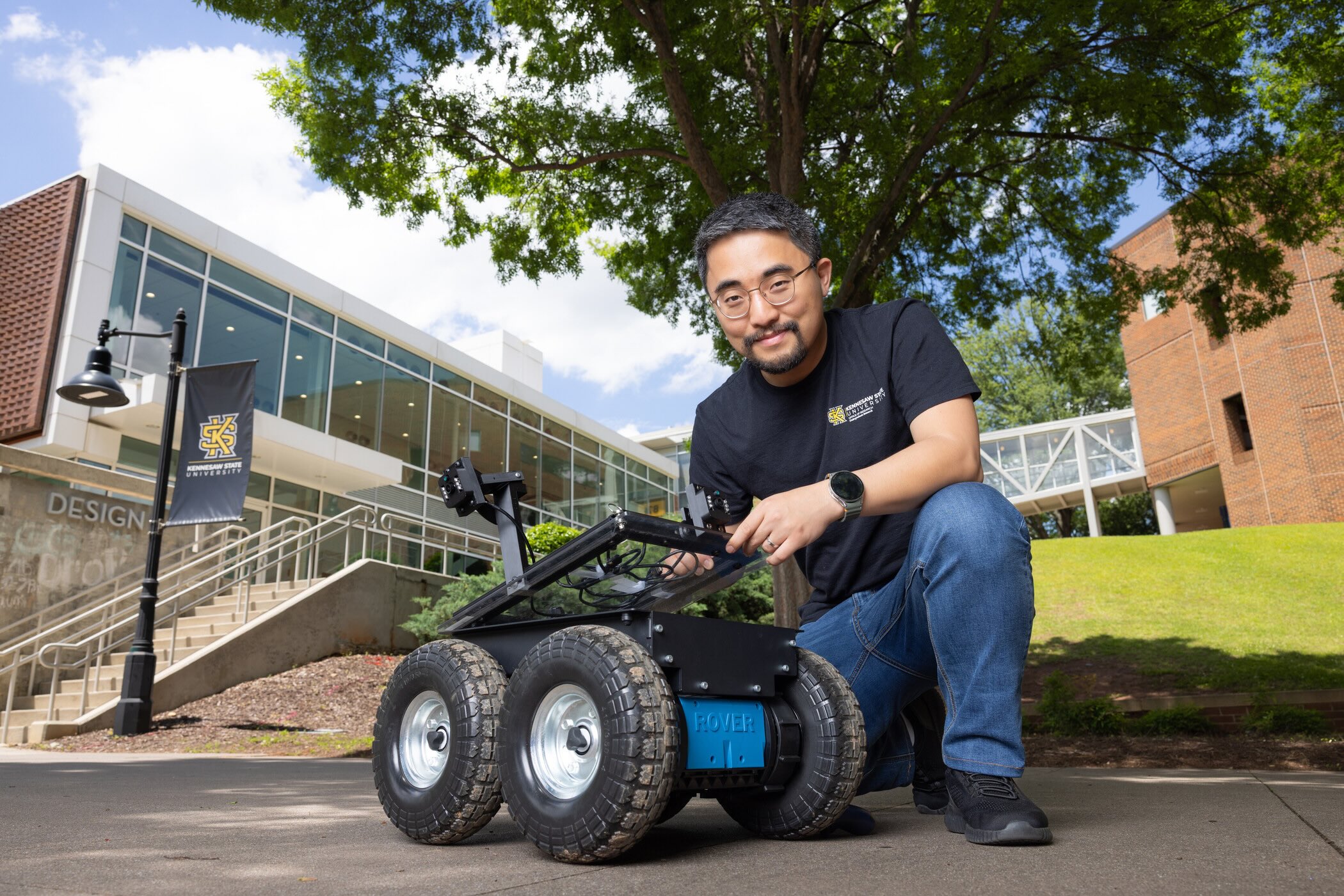 researcher kneeling over robotic device
