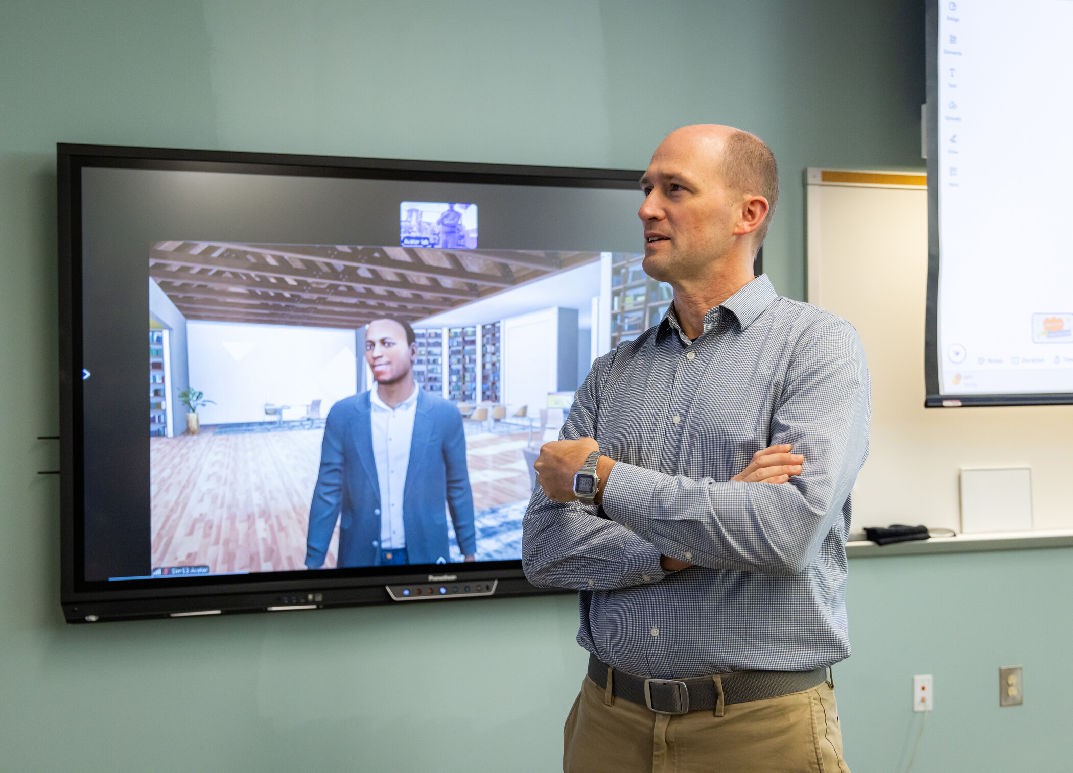 researcher standing in front of screen showing augmented reality avatar.
