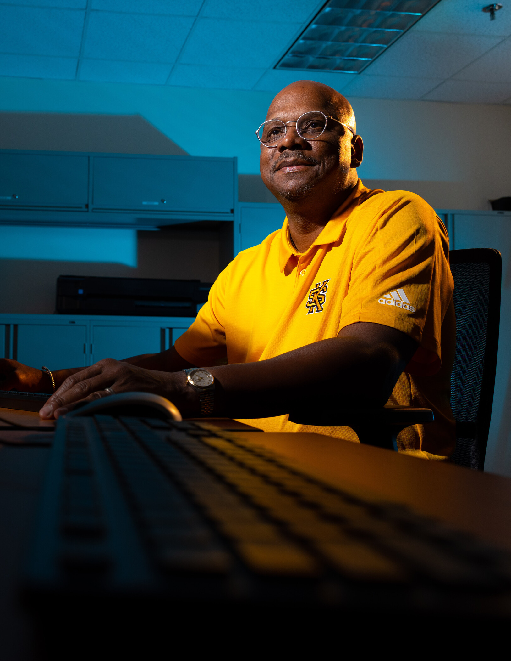 researcher sitting in front of computer in a dark room.