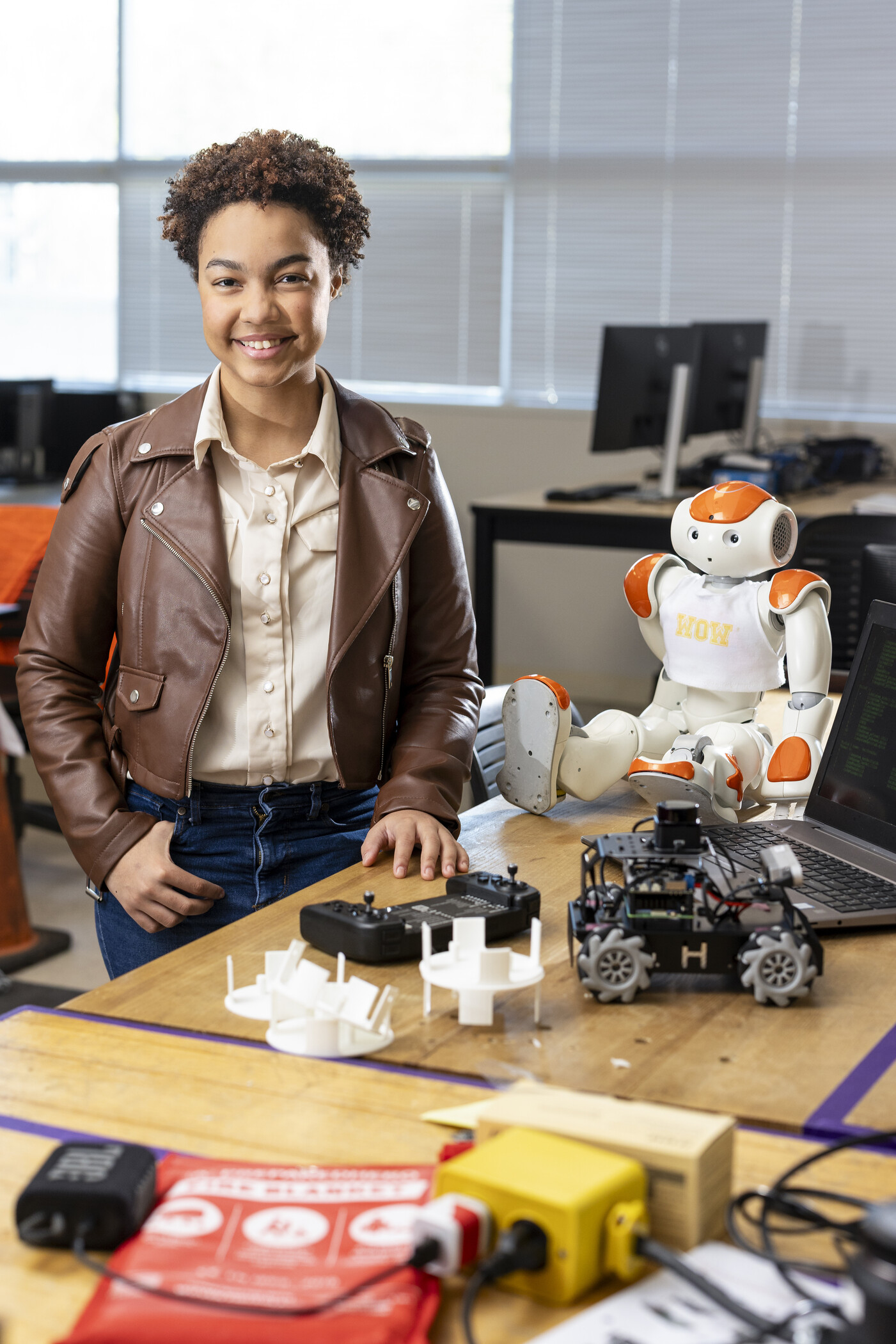 researcher standing next to table with various robotics tools.