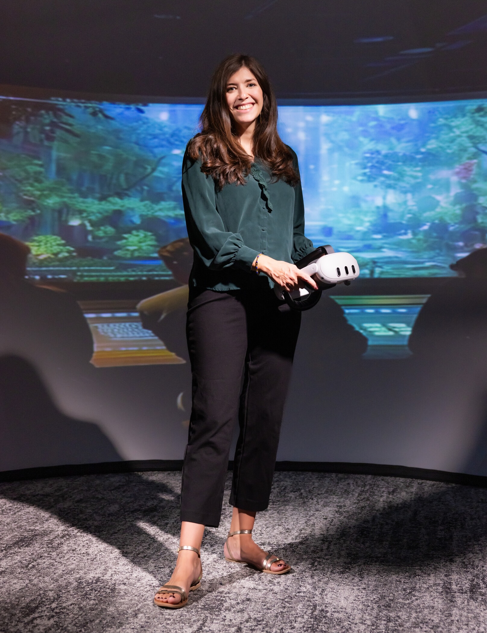 researcher holding virtual reality headset in front of simulation environment.