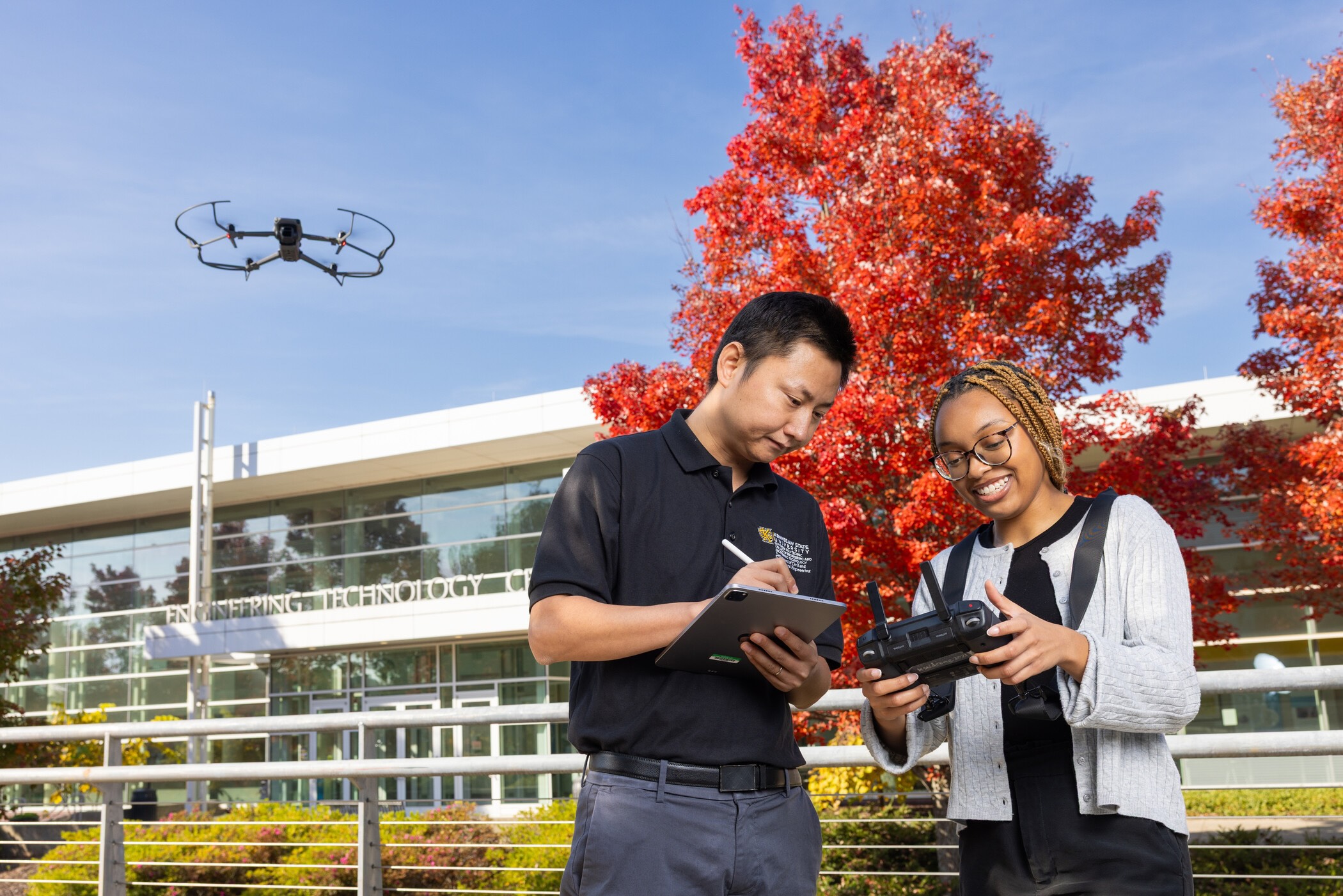 two researchers compiling data as a drone flies overhead.