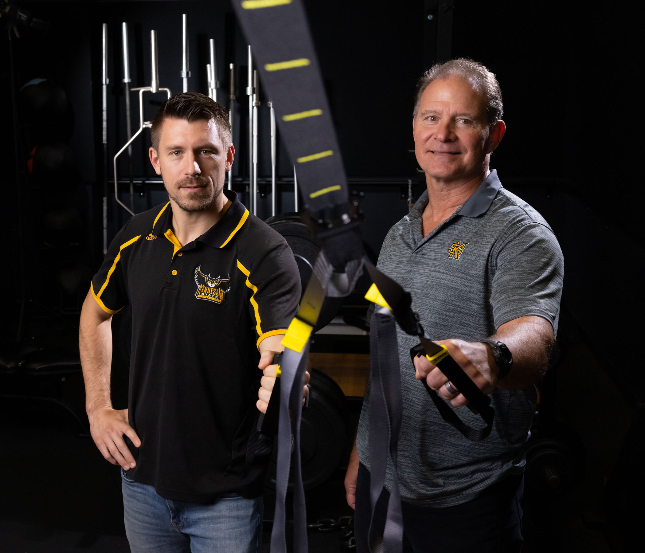 two researchers holding workout gear.