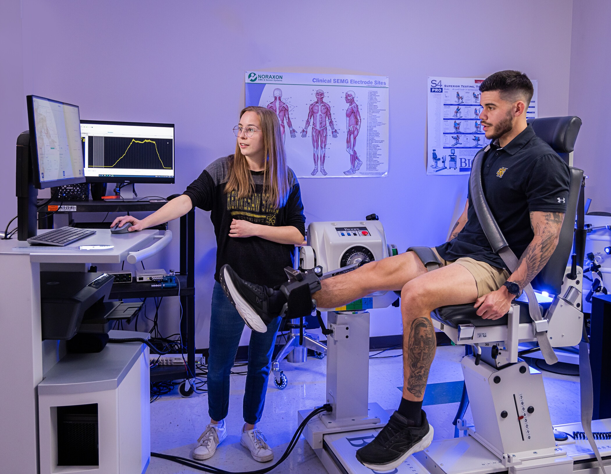 researcher reading results on monitor while patient sits in chair.