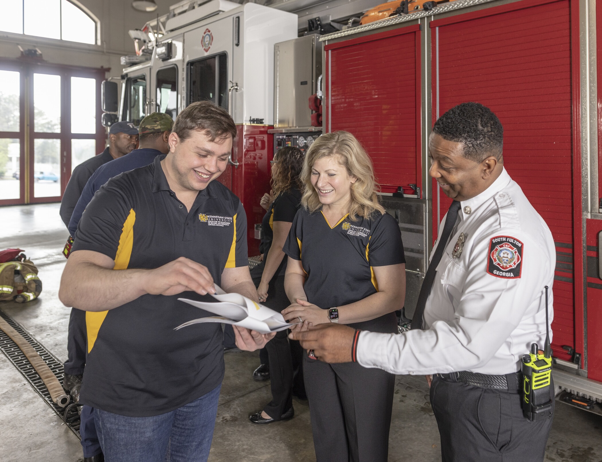 three people examining document in fire station.