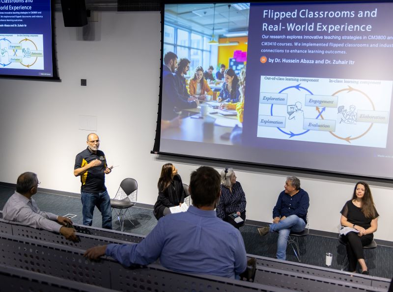 People attend a lecture on flipped classrooms and real-world experience