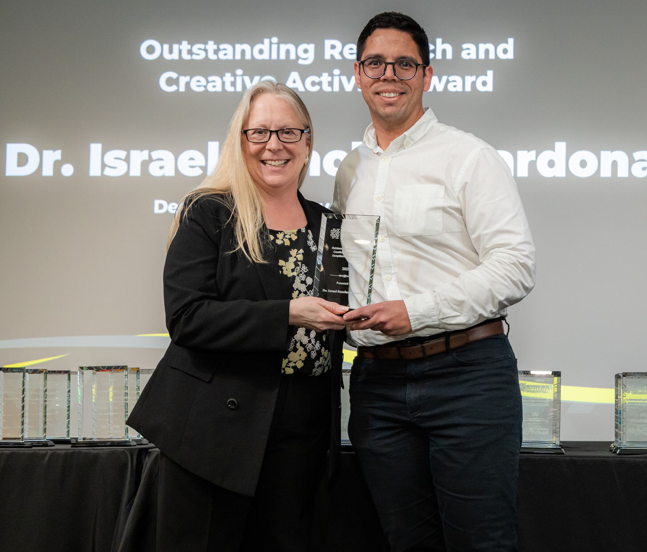 man receiving award from woman