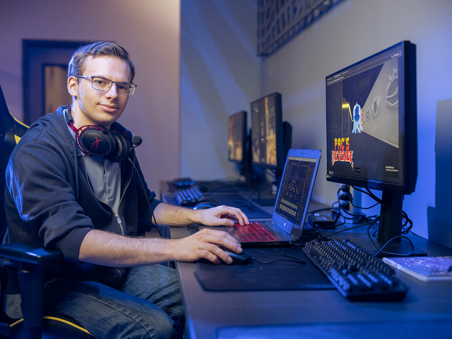 male game designer on computer smiling
