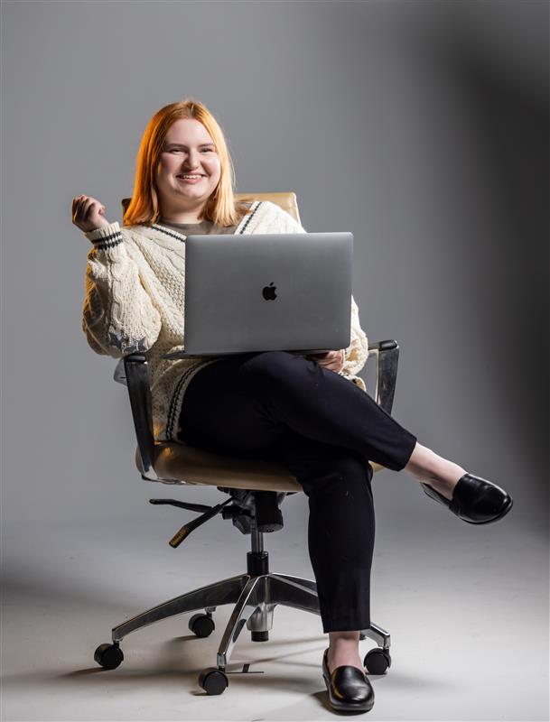 Student Amelia Baker siting in a chair with her laptop