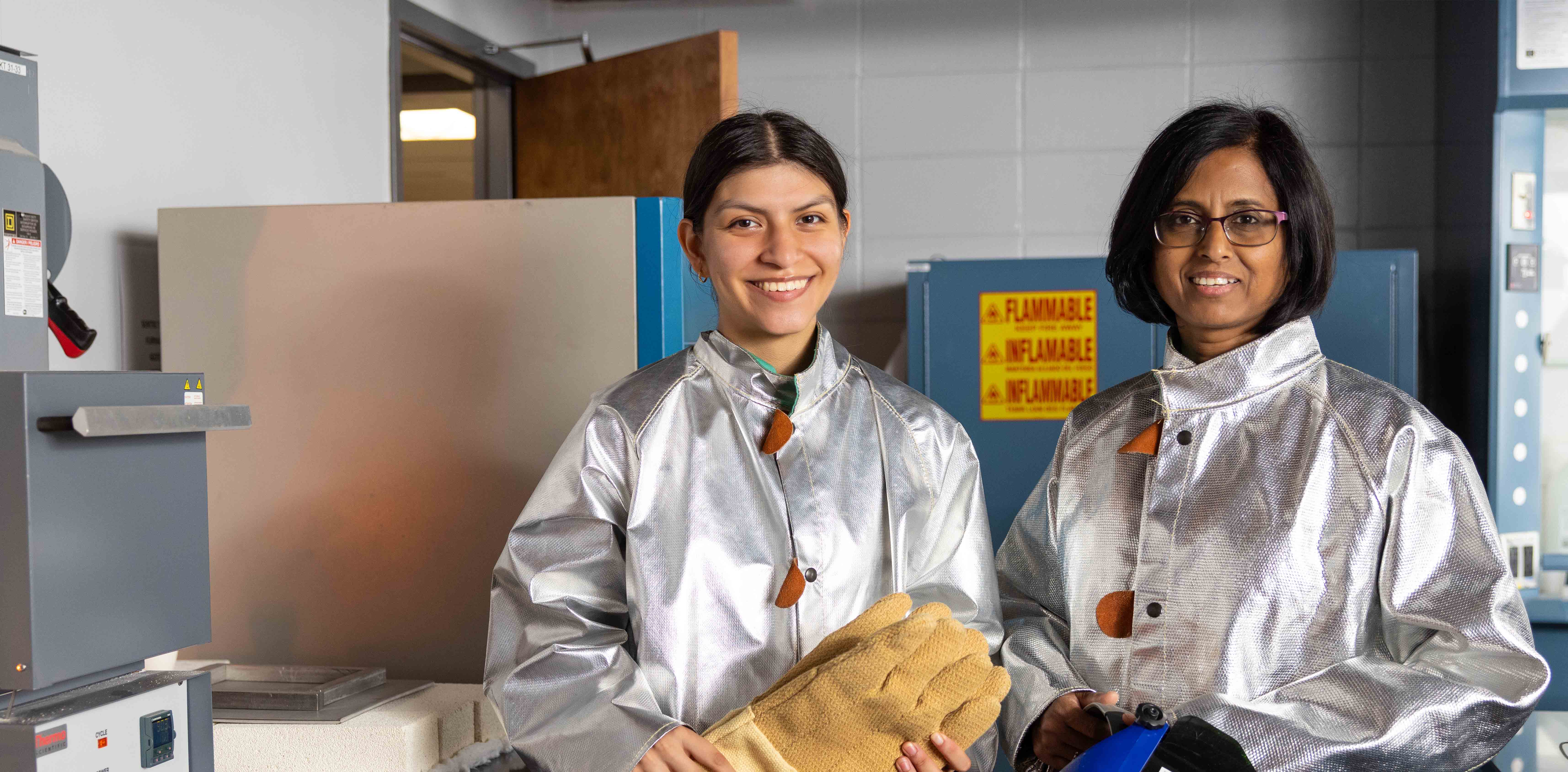 ksu lab teacher and scholar student doing research while smiling