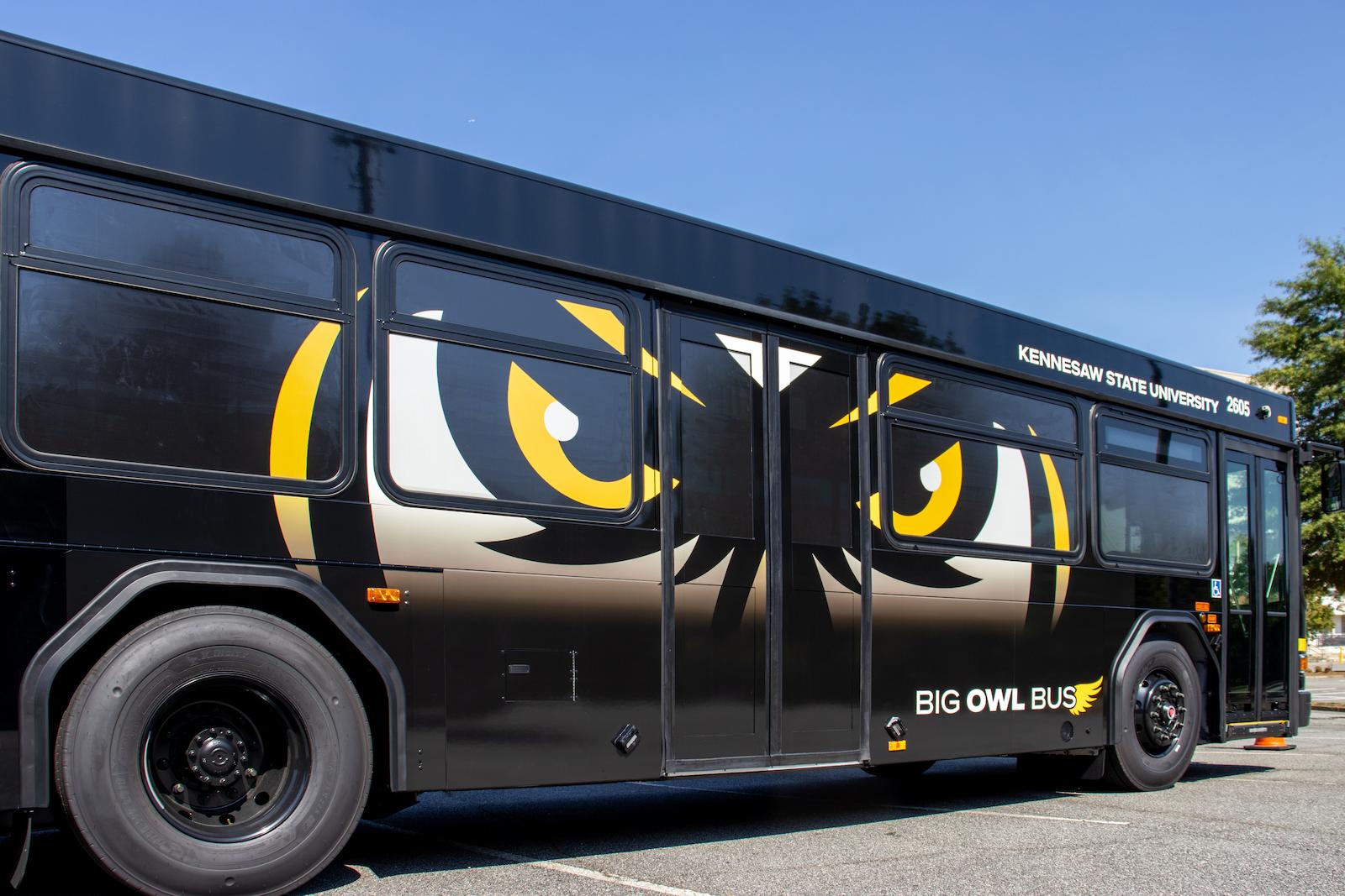 side view of the new big owl bus designs featuring owl eyes on a black bus