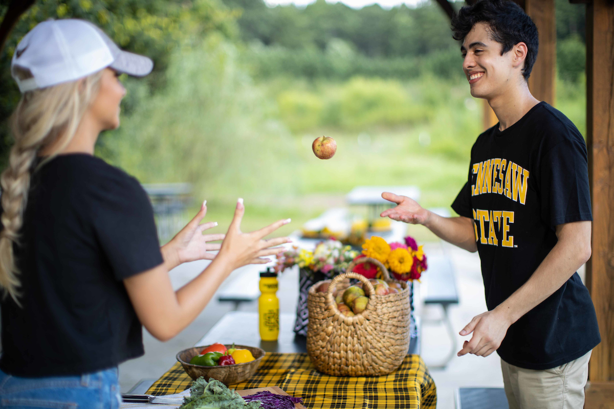 boy tossing apple to girl 