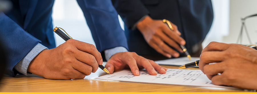 A diverse group of individuals actively signing documents