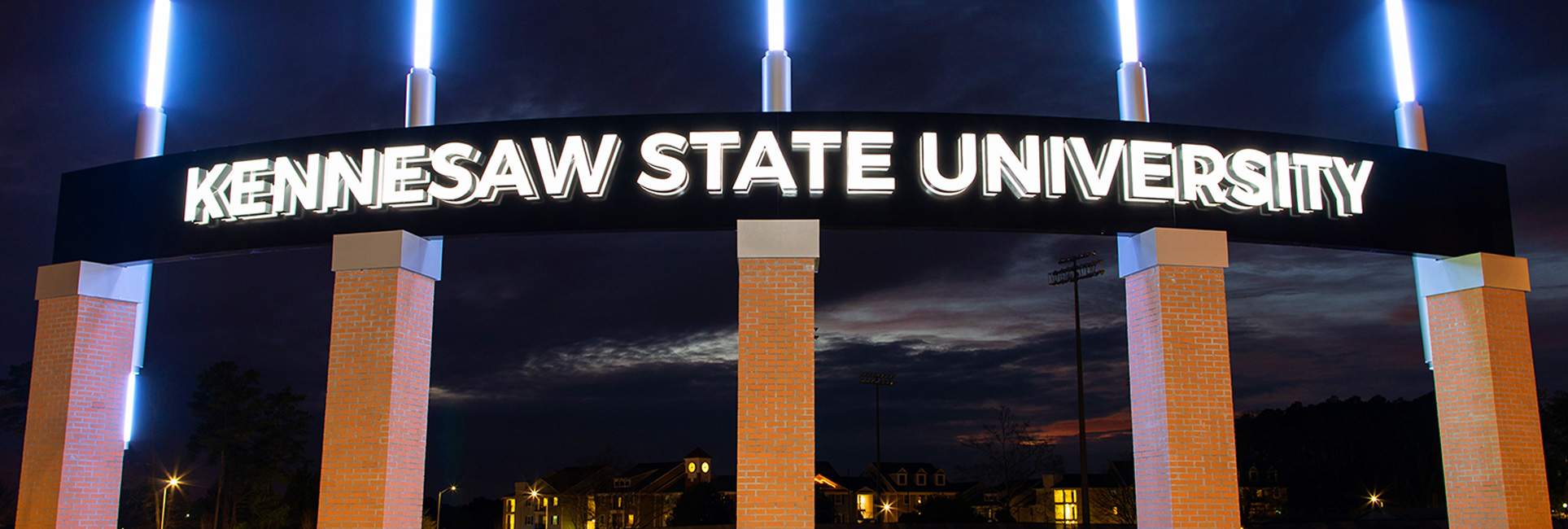 Kennesaw State University campus sign glowing at dusk